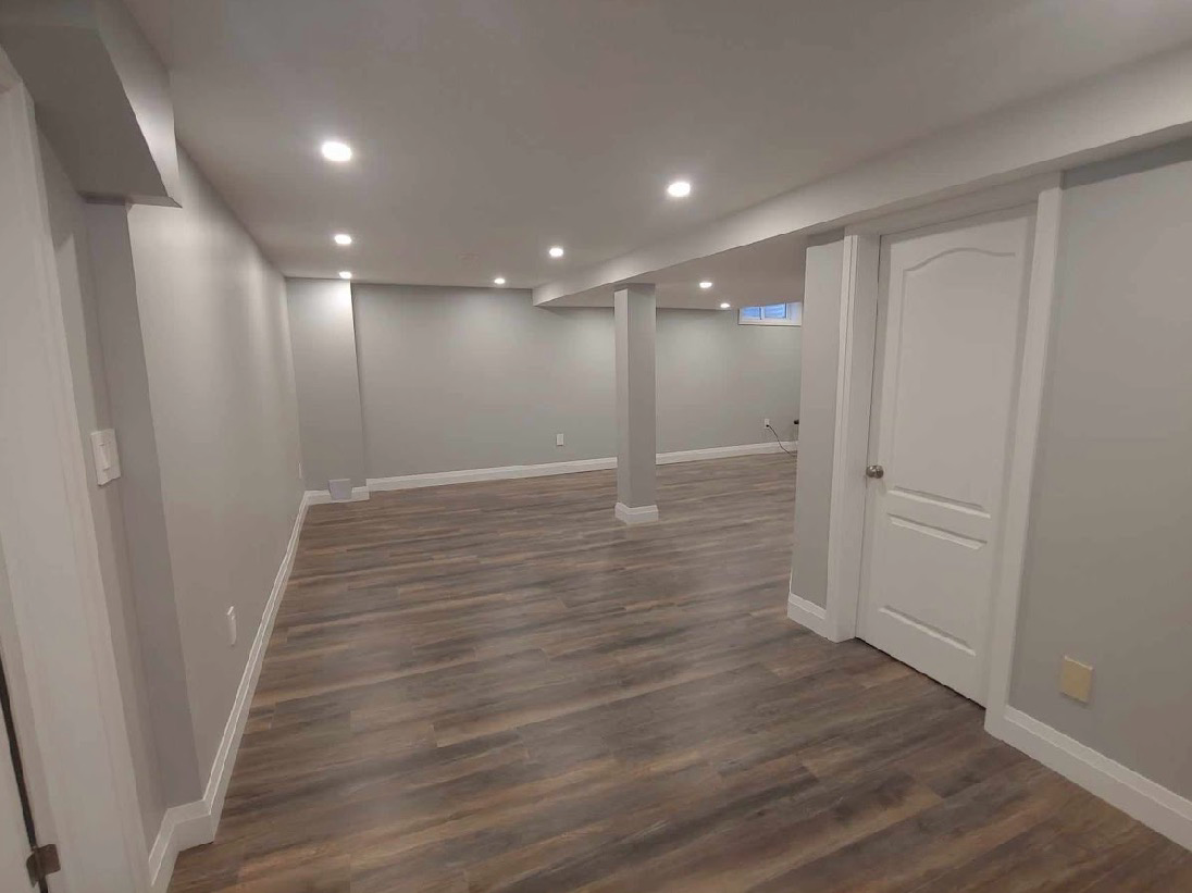 Finished basement with recessed lighting and wood-look flooring, first angle